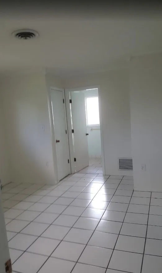Empty room with white walls, white doors and white tile floor