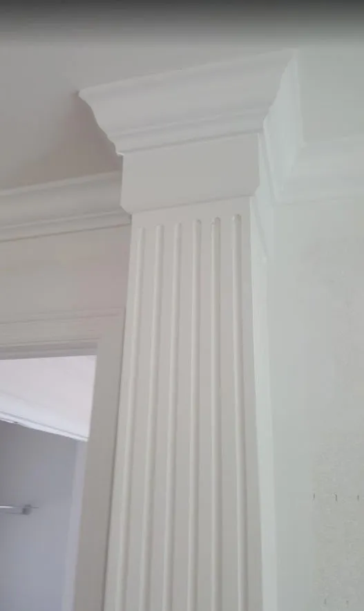 White fluted pilaster with crown molding in a painted interior