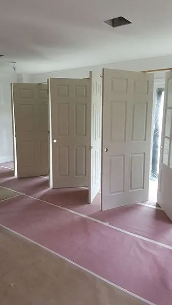Interior doors stood upright for painting on pink floor protection paper